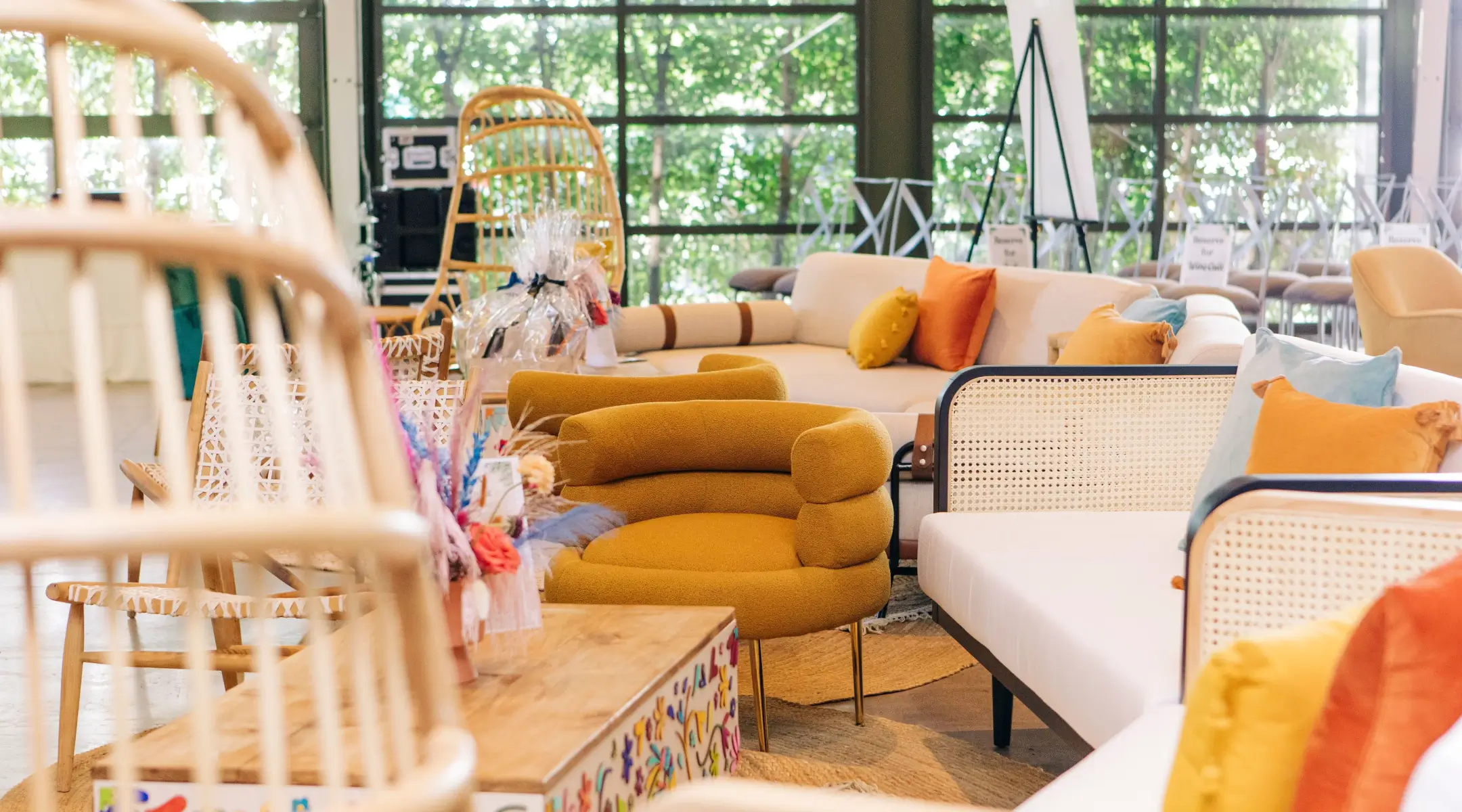 Dang Fine - A sunlit indoor event space with large windows looking out onto green trees. The lounge area is decorated with modern bohemian furniture.